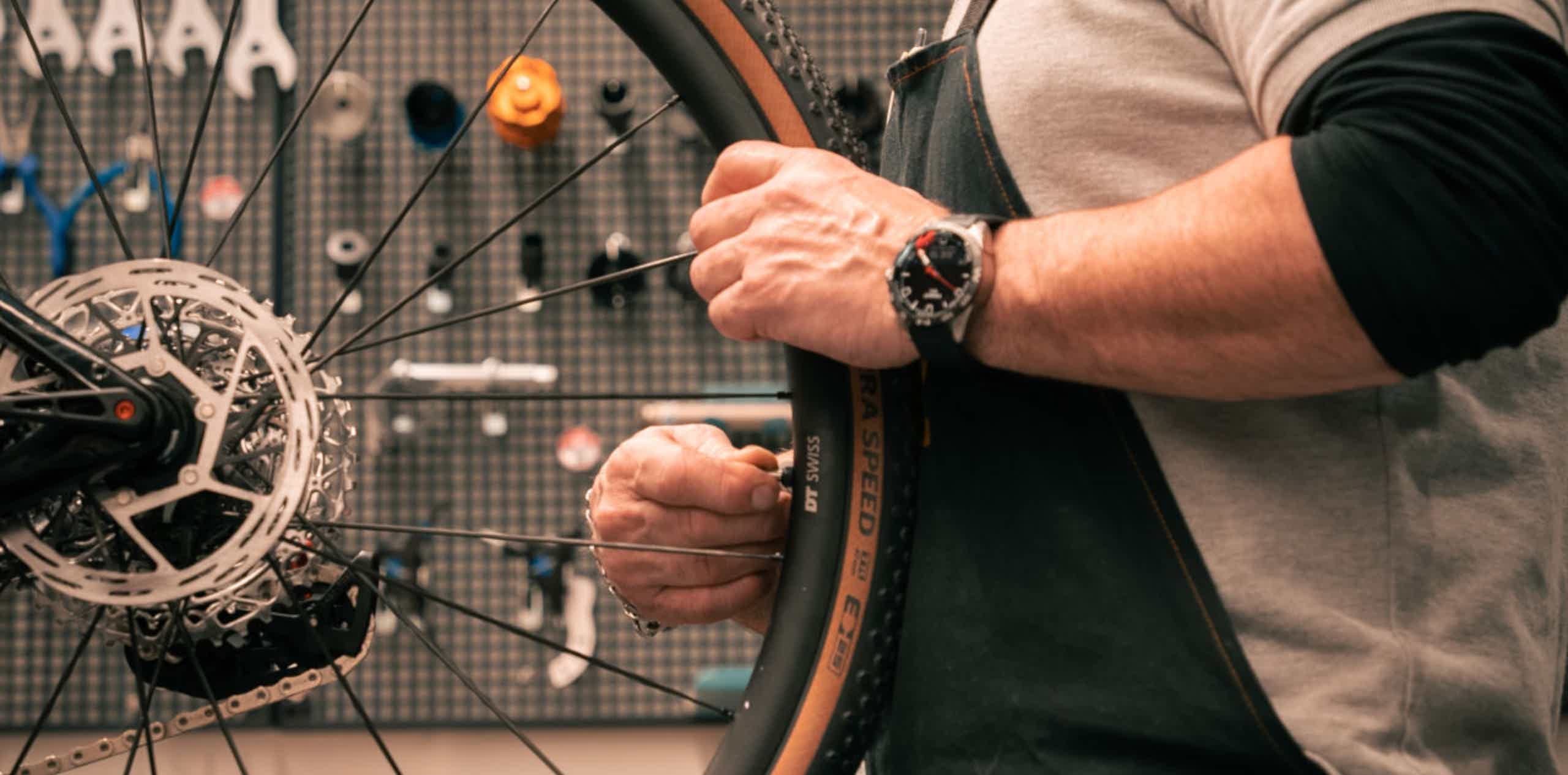 Imagen de recurso de una persona en un taller con una rueda de una e-bike.
