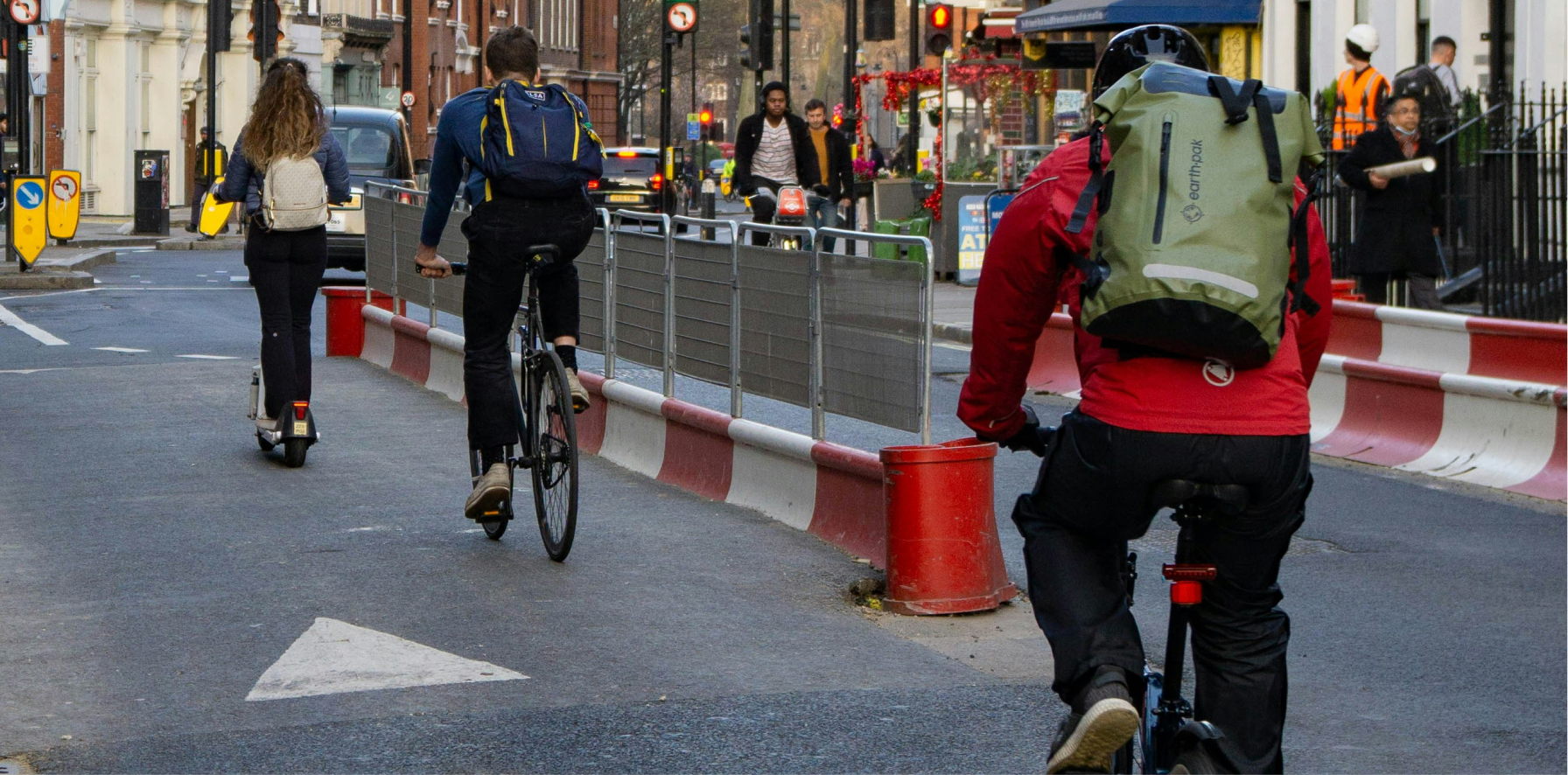 personas yendo al trabajo en bicicleta electrica y patinete electrico