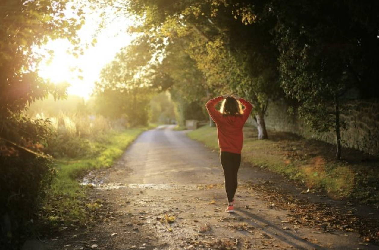 person walking down a road in fall