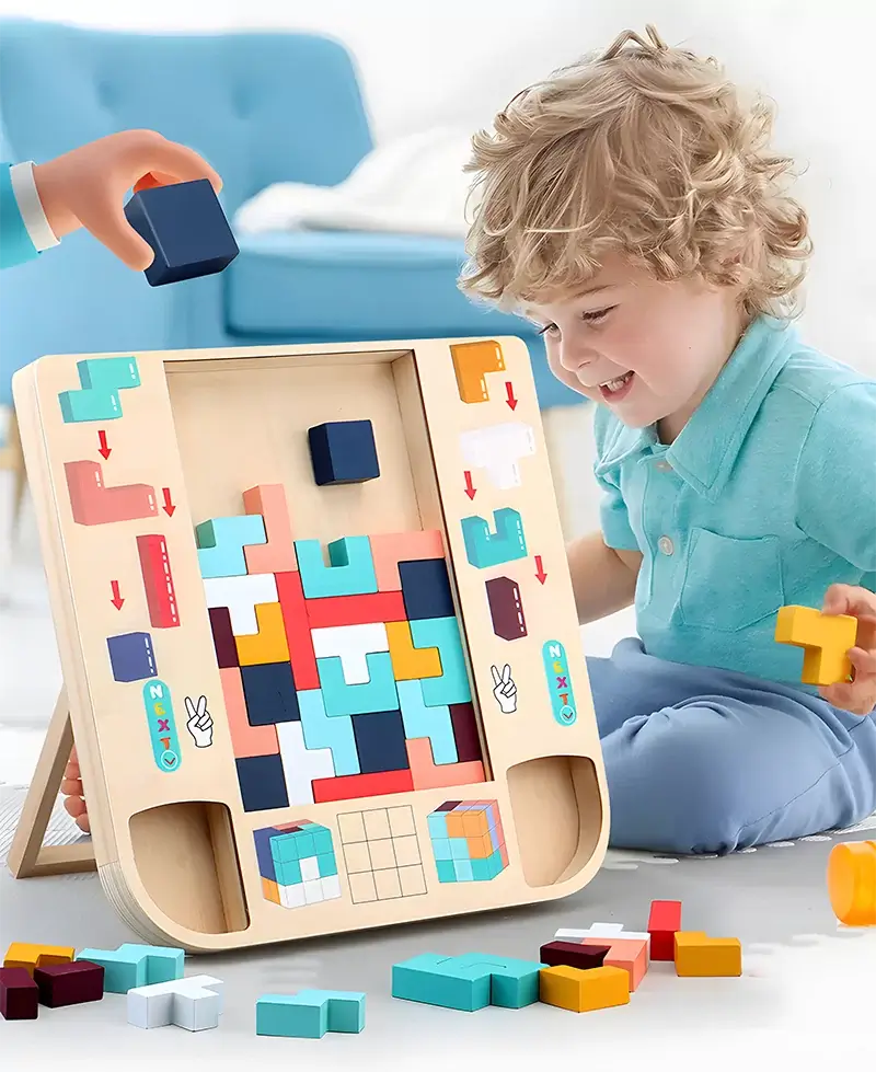 Kisfiú ül egy Montessori Tetris mellett, és darabokat rak a fából készült Tetris táblába.