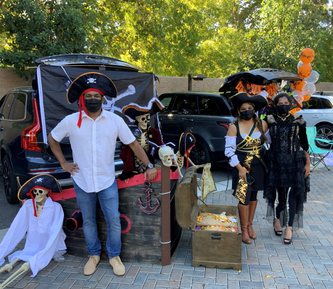 parents dressed up as pirates with their car decorated as a pirate ship for our trunk-or-treat event 