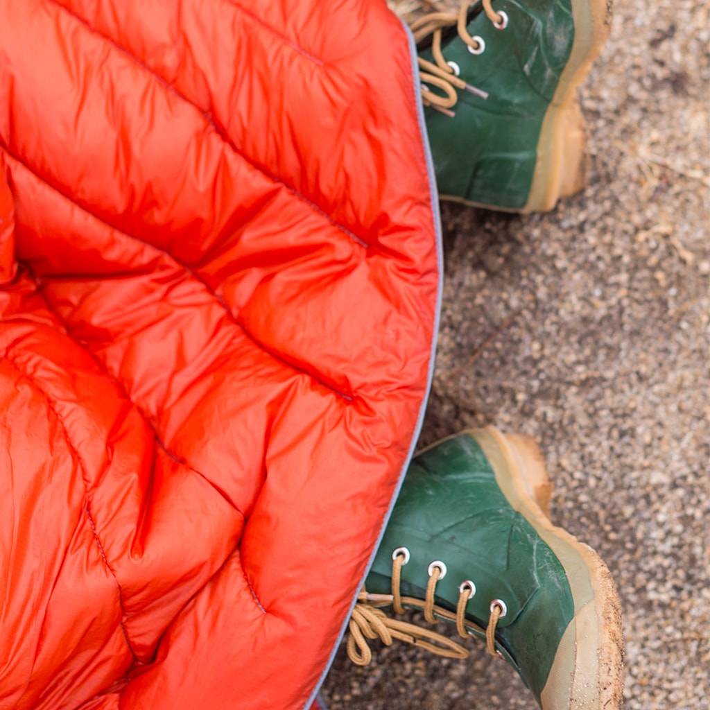 Red Rumpl camping blanket and green boots