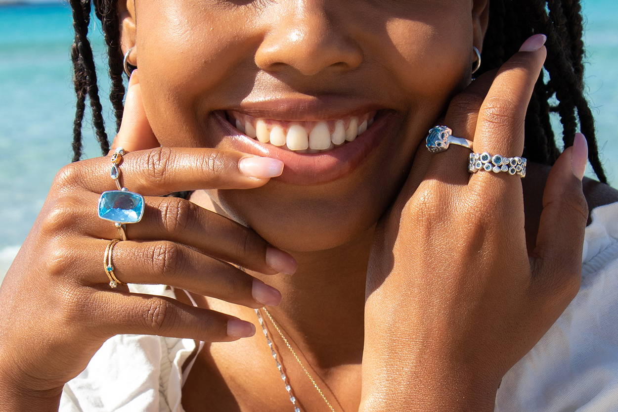 Women smiling and showing off her layered Vibe Jewelry rings.