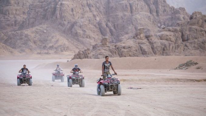 SHARM EL-SHEIKH, EGYPT - Quad bikes safari in desert near Sharm El Sheikh, Egypt. Powerful fast off-road four-wheel drive ATVs, motorcycles in sandy desert, rally against high mountains