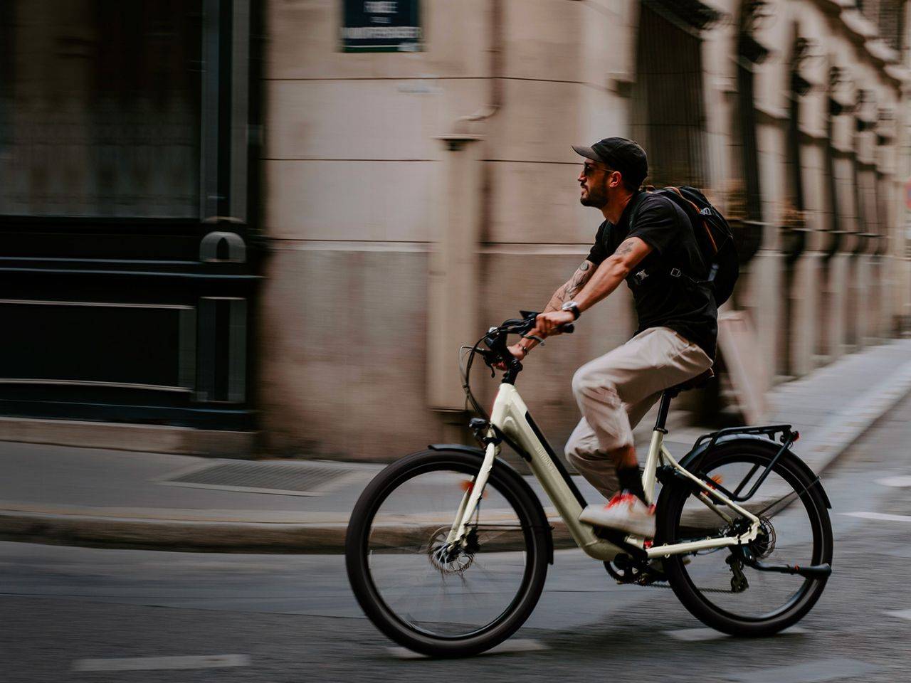Un homme utilisant son vélo électrique reconditionné ShiftBikes pour se rendre au travail