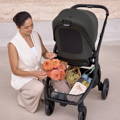 Lifestyle photo featuring a parent using the Redsbaby ONIX pram outdoors.