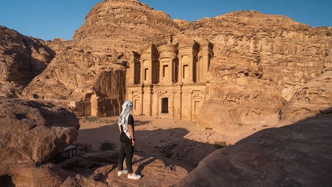 A man standing in front of the Monastery or Ad Deir in Petra ruin and ancient city in Jordan, UNESCO world heritage site, Asia