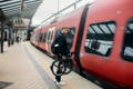 Un vélotafeur en train d’attendre le train avec son vélo pliant électrique