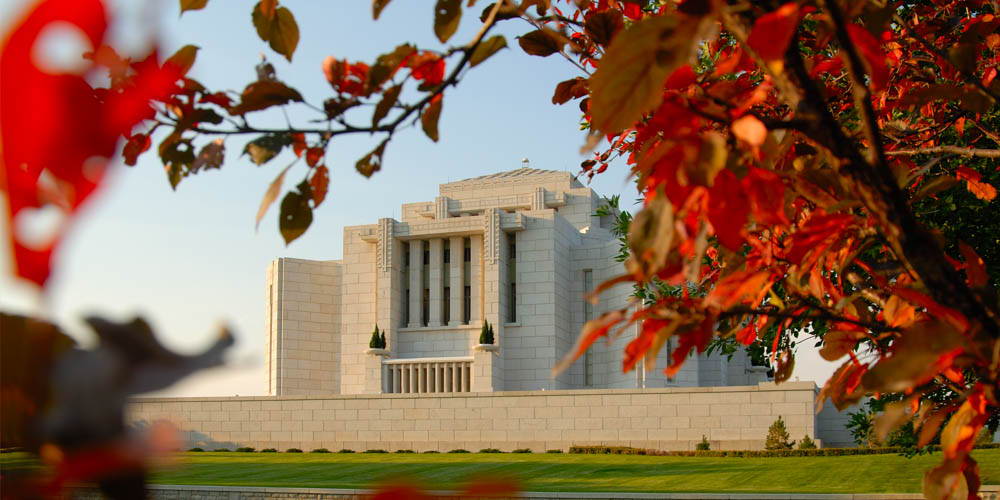 The Cardston Temple framed by red and and orange leaves.