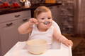 Baby putting a decoration on a birthday cake.