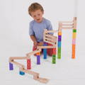Little boy playing with a wooden stacking marble run.