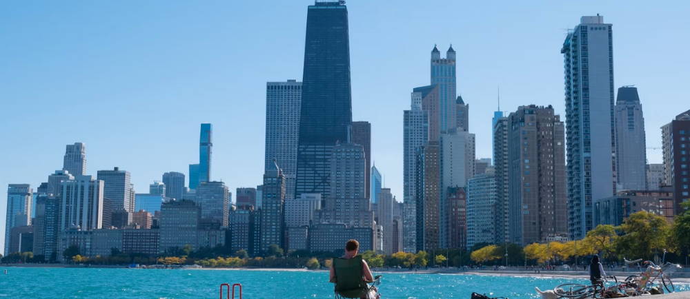 man in front of water and skyline of Chicago