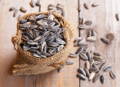 sunflower seeds in a burlap sack with some seeds spilt over the edge 