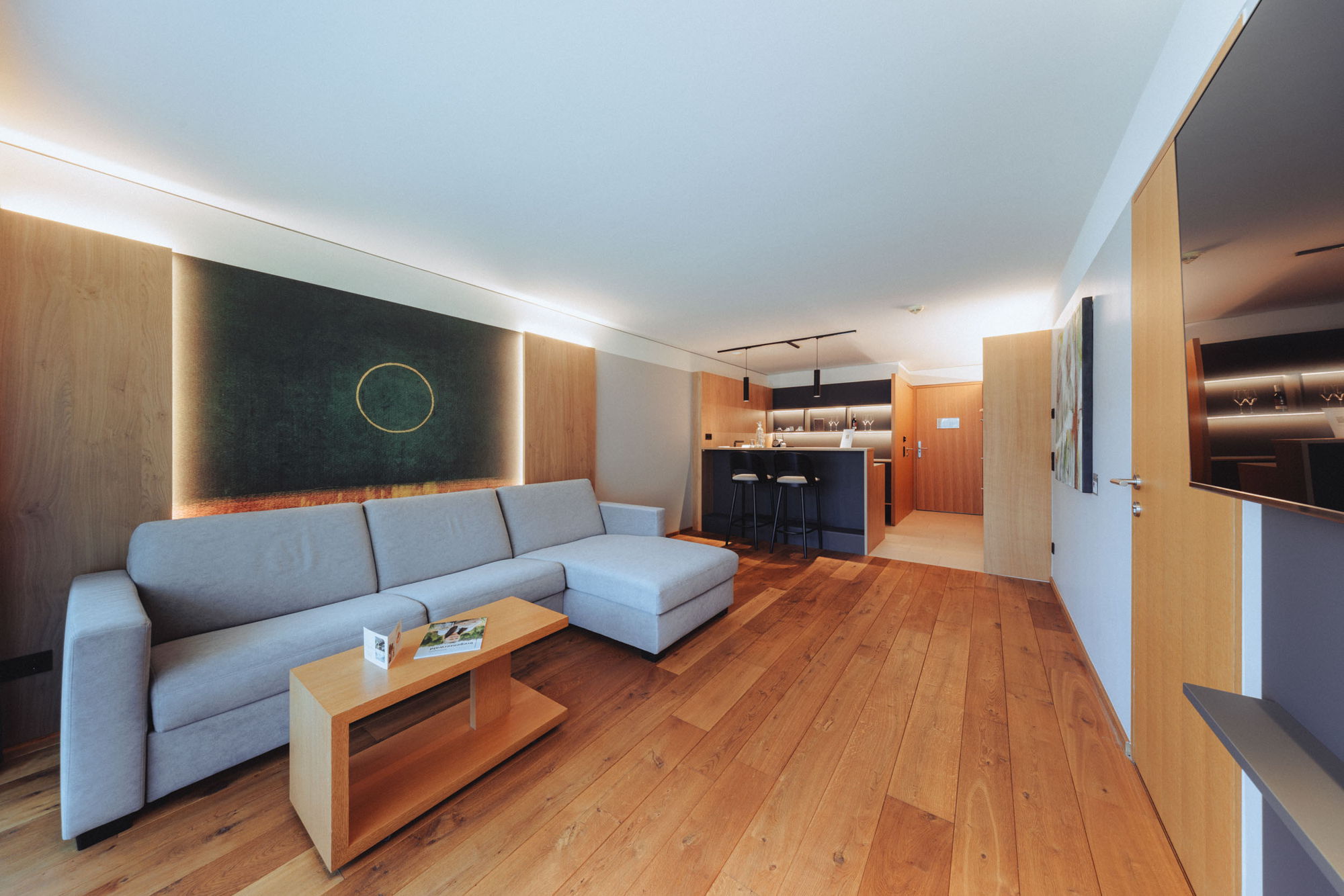 Großzügiger Wohnbereich der Feel good Suite mit Sofa und offener Küche