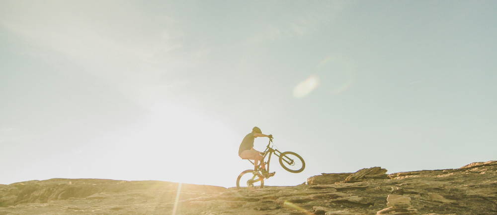 a man doing a wheelie on an electric mountain bike