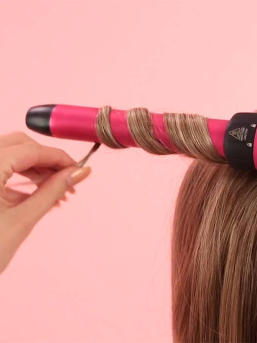 Hot curling iron being used to style a wig.