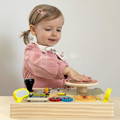 Little girl playing with a Montessori Busy Dashboard.