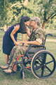 young military veteran in a wheelchair kissing his spouse