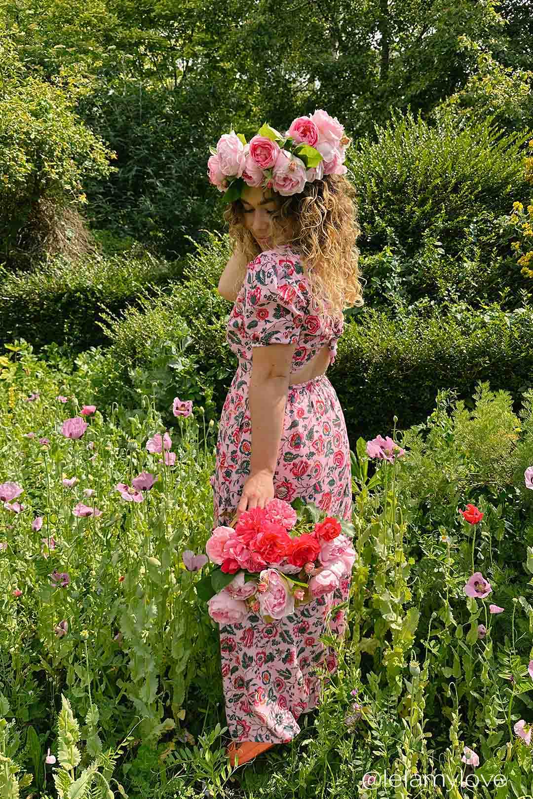 Lela May Love wears the Yolke Barbie pink floral open back Bow dress.