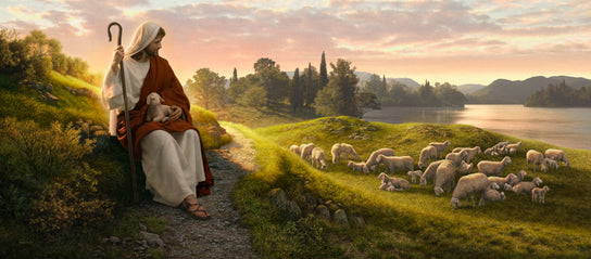 Jesus sitting on a hill with a lamb in His lap and watching over a flock.