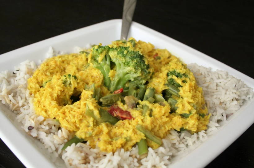 A big plate of rice with coconut curry sauce on top.