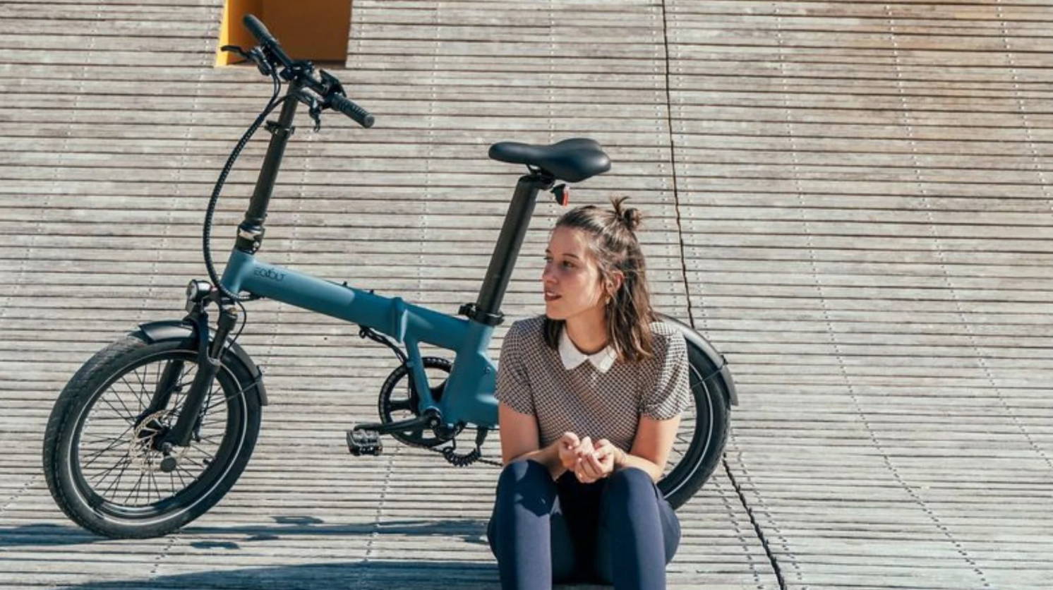 Une femme se promène à Paris avec son vélo pliant acheté chez ShiftBikes