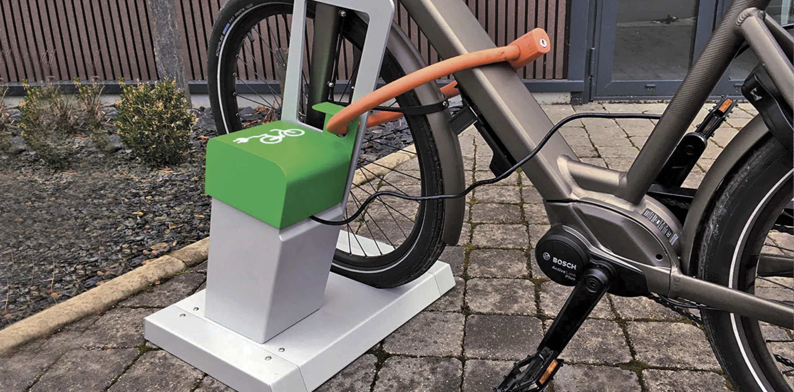Imagen de recurso de una e-bike en un aparcabicis y cargando a la vez.