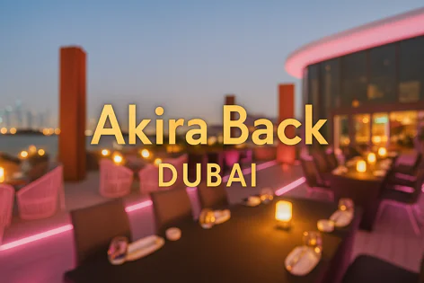 Rooftop terrace restaurant in Dubai at dusk with tables, chairs, ambient candles, and pink neon lighting. City skyline visible in the background.