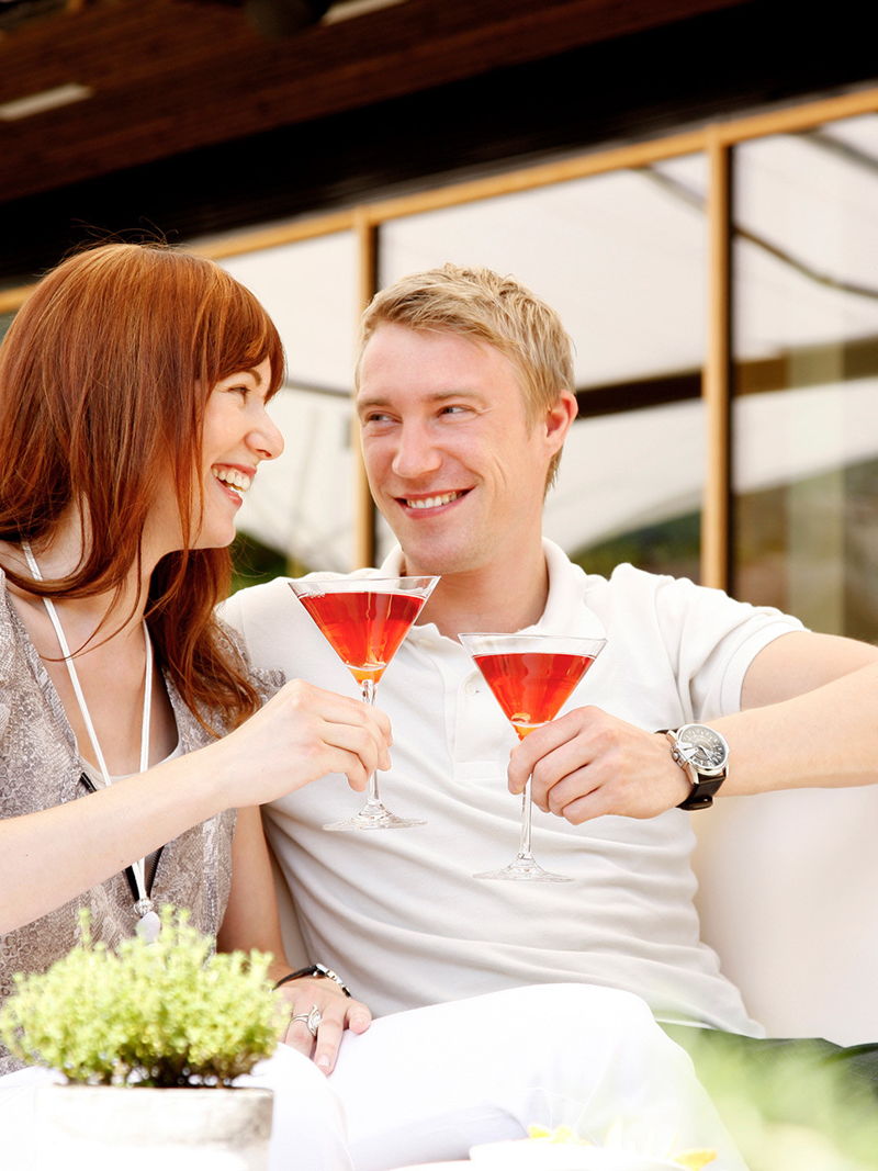 Frau und Mann trinken Cocktails auf der Terrasse