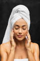woman with a towel on her head checking if her skin is purging