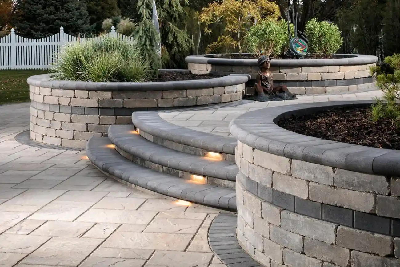 Multiple circular retaining wall systems made with Weston Wall Blocks filled with plants on a multi-level patio.