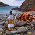 Bouteille de Ardnamurchan Single Malt Scotch Whisky posée sur une plage de galets à la distillerie Ardnamurchan dans les Highlands de l'ouest d'Ecosse