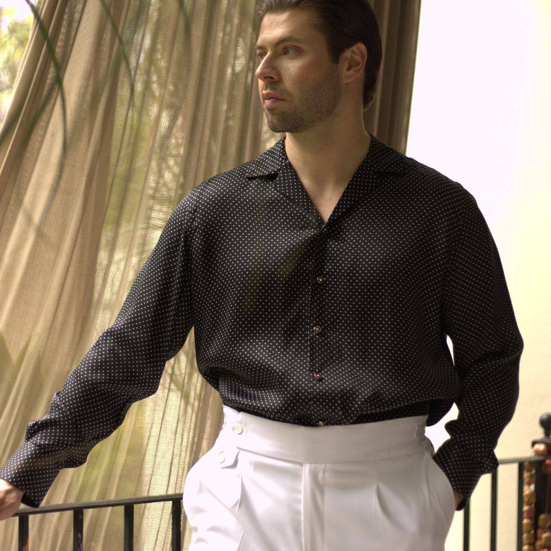 model wearing white pants and a long sleeve black dotted silk shirt from 1000 kingdoms