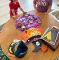Siblings decorating the Montessori Halloween Pumpkin on a wooden table. 