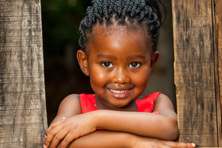 pretty african youngster leaning on wooden fence outdoors.jpg