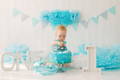 Baby putting a decoration on a birthday cake.