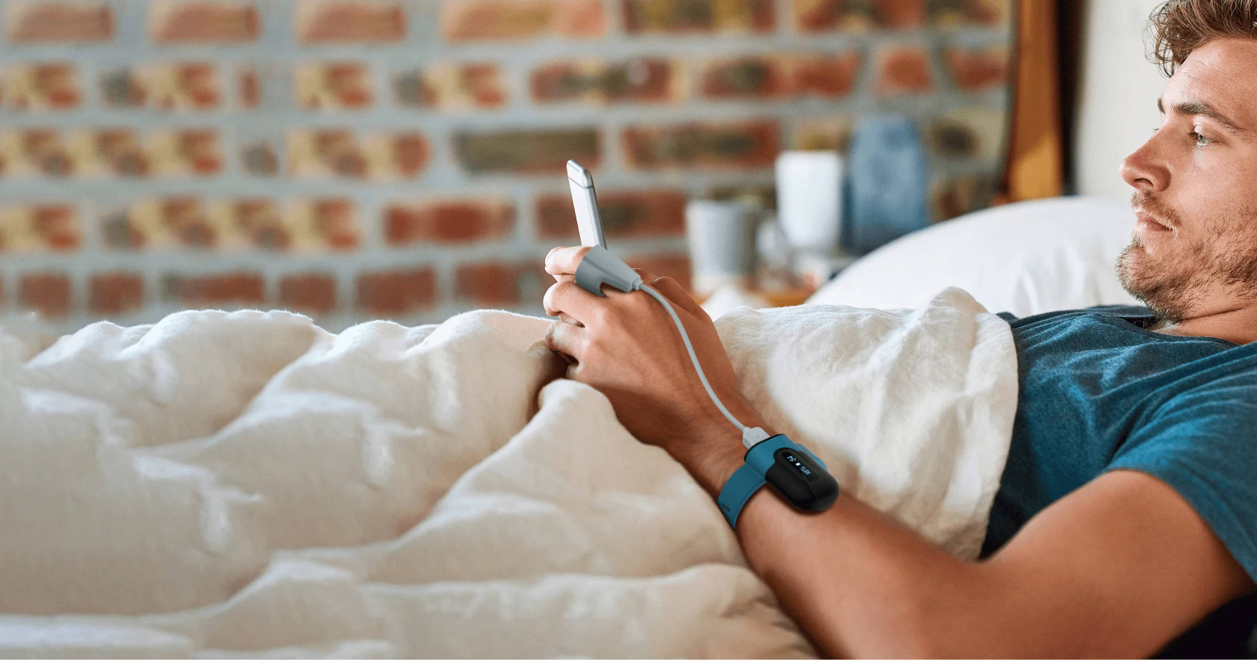 Man wearing Wellue SleepU wrist oxygen monitor in bed for overnight tracking
