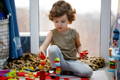 Little autistic boy playing with wooden Montessori blocks. 