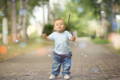 Cheerful little boy in the park holding a branch. 