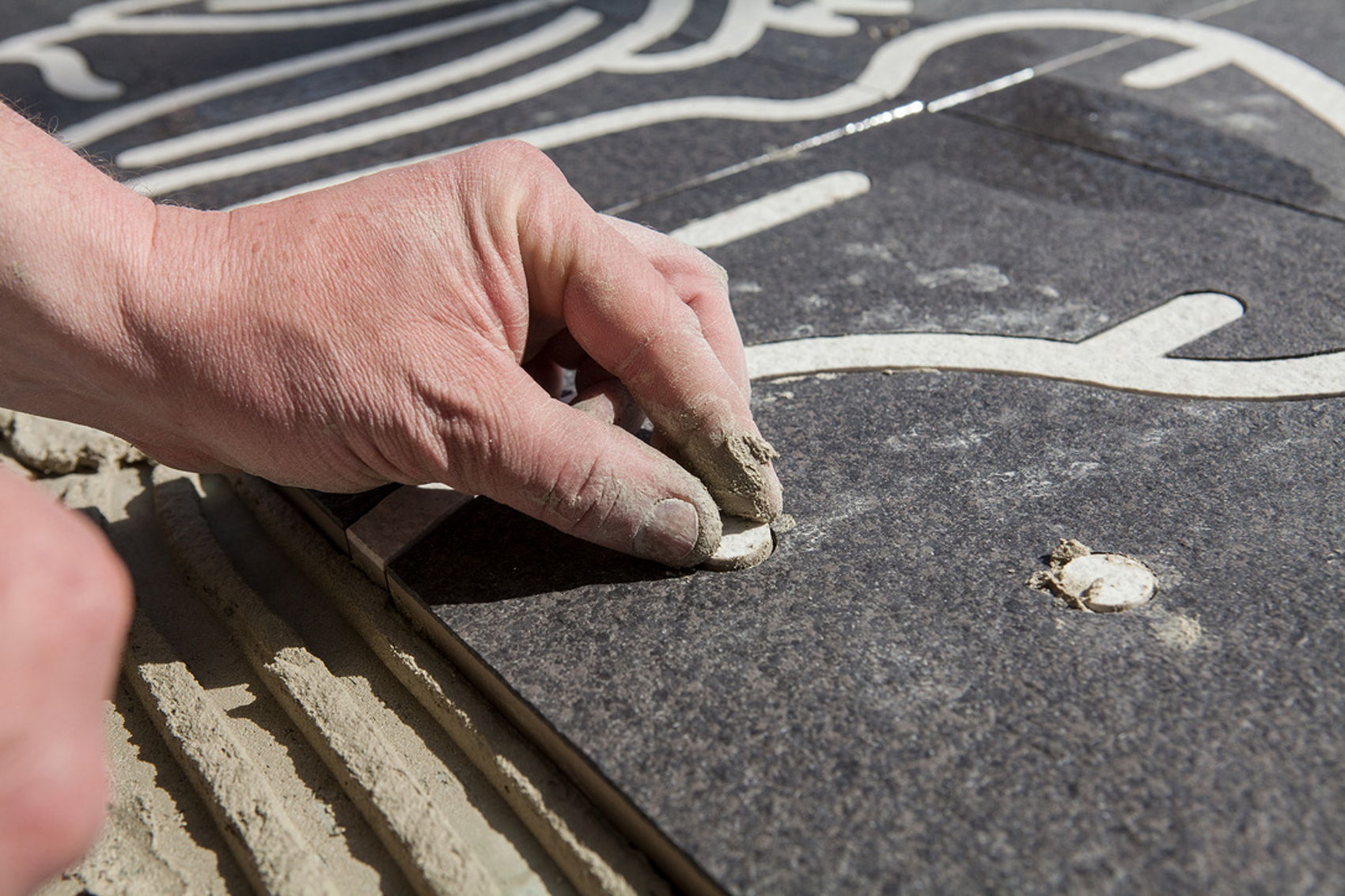 Links: Met de tekeningen in zijn hand bekijkt kunstenaar Harmen Liemburg de uitvoering van zijn kunstwerk. In een paar weken tijd werd het kunstwerk op de vloer gelegd. Foto: Jorrit 't Hoen Boven: Precisie werk: elke uitgesneden onderdeel werd met de hand ingelegd. Foto: Jorrit 't Hoen Links: Met de tekeningen in zijn hand bekijkt kunstenaar Harmen Liemburg de uitvoering van zijn kunstwerk. In een paar weken tijd werd het kunstwerk op de vloer gelegd. Foto: Jorrit 't Hoen Boven: Precisie werk: elke uitgesneden onderdeel werd met de hand ingelegd. Foto: Jorrit 't Hoen