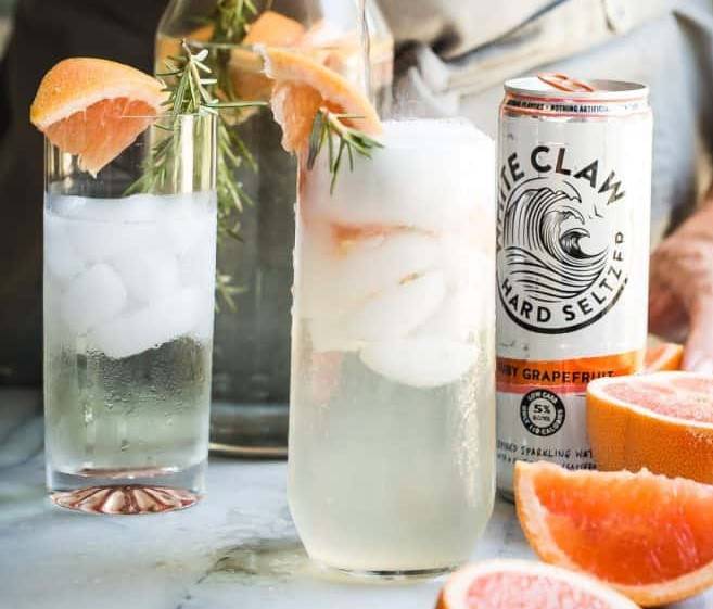Two glasses of grapefruit sparkling seltzer and a White Claw