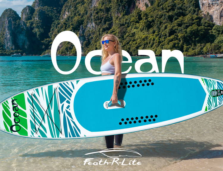 This woman is holding a Feath-r-lite inflatable stand up paddle board with standing in the water
