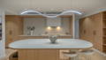 Kitchen Wide Havit custom sinuous LED strip installation above curved stone kitchen island with timber cabinetry, downlights and rangehood lighting, Manly QLD