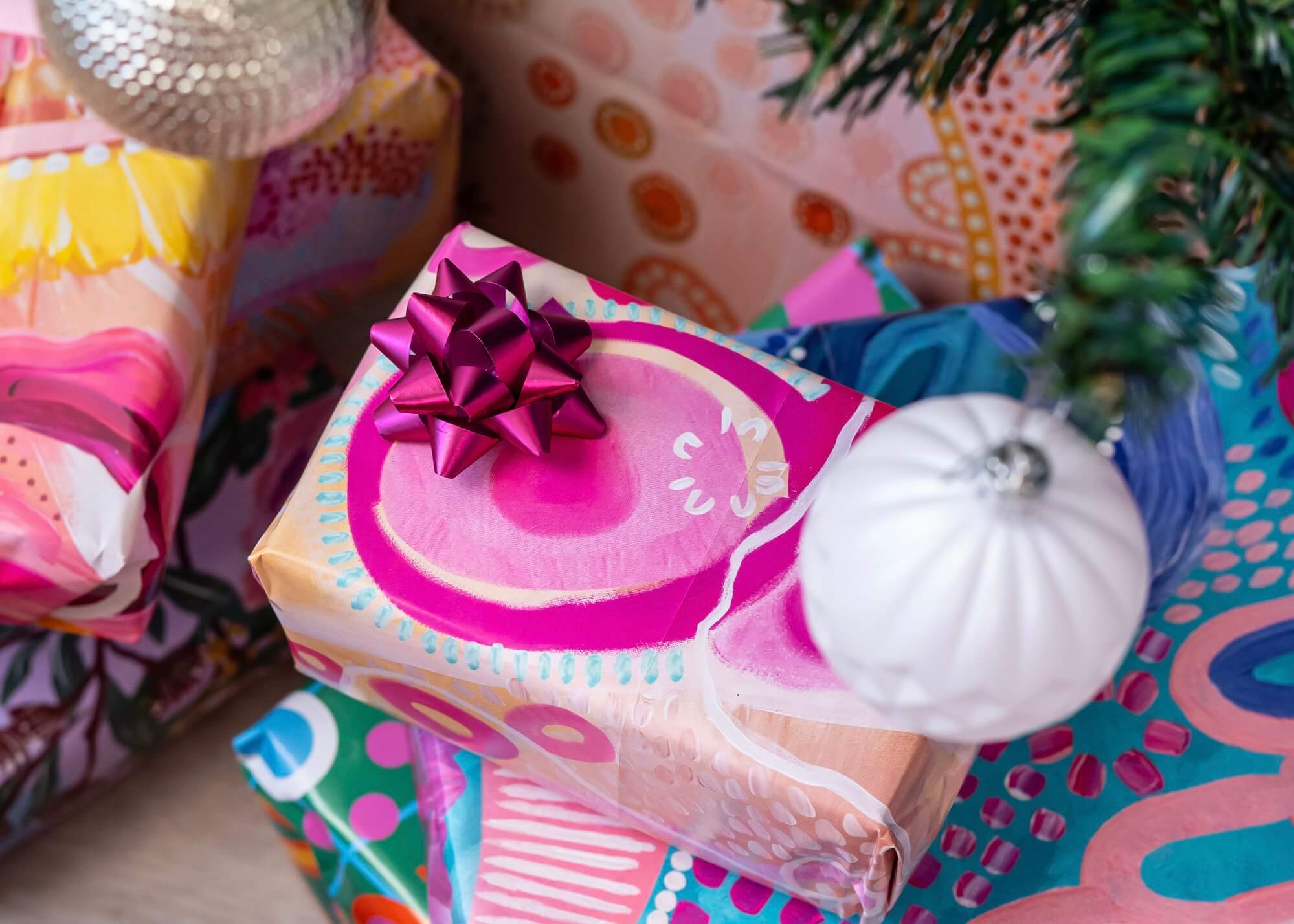 Pink wrapped gift under a christmas tree