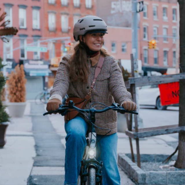 a woman riding in the city on a commuter electric bike