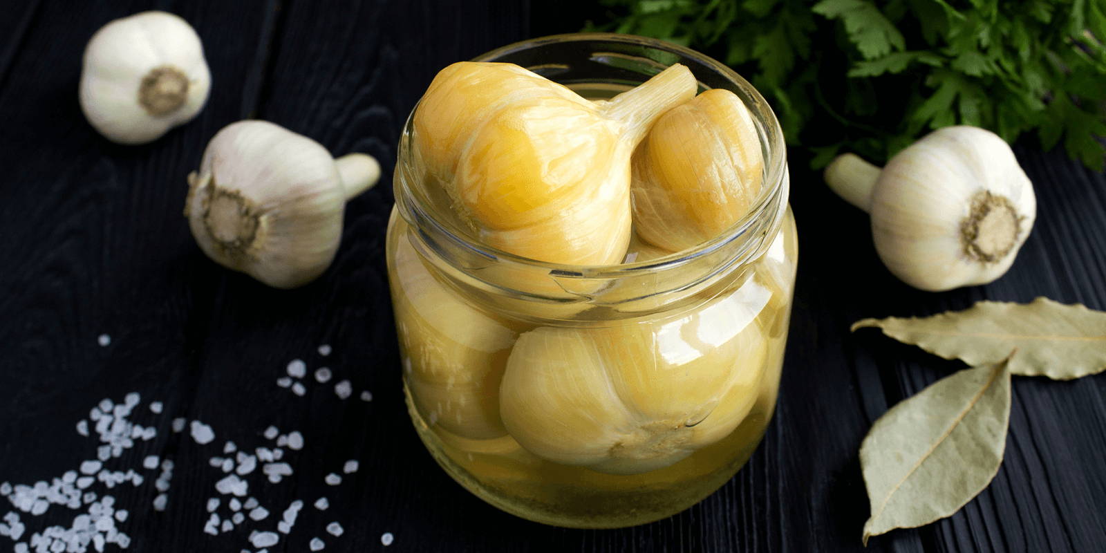 Roasted garlic in a jar filled with oil.