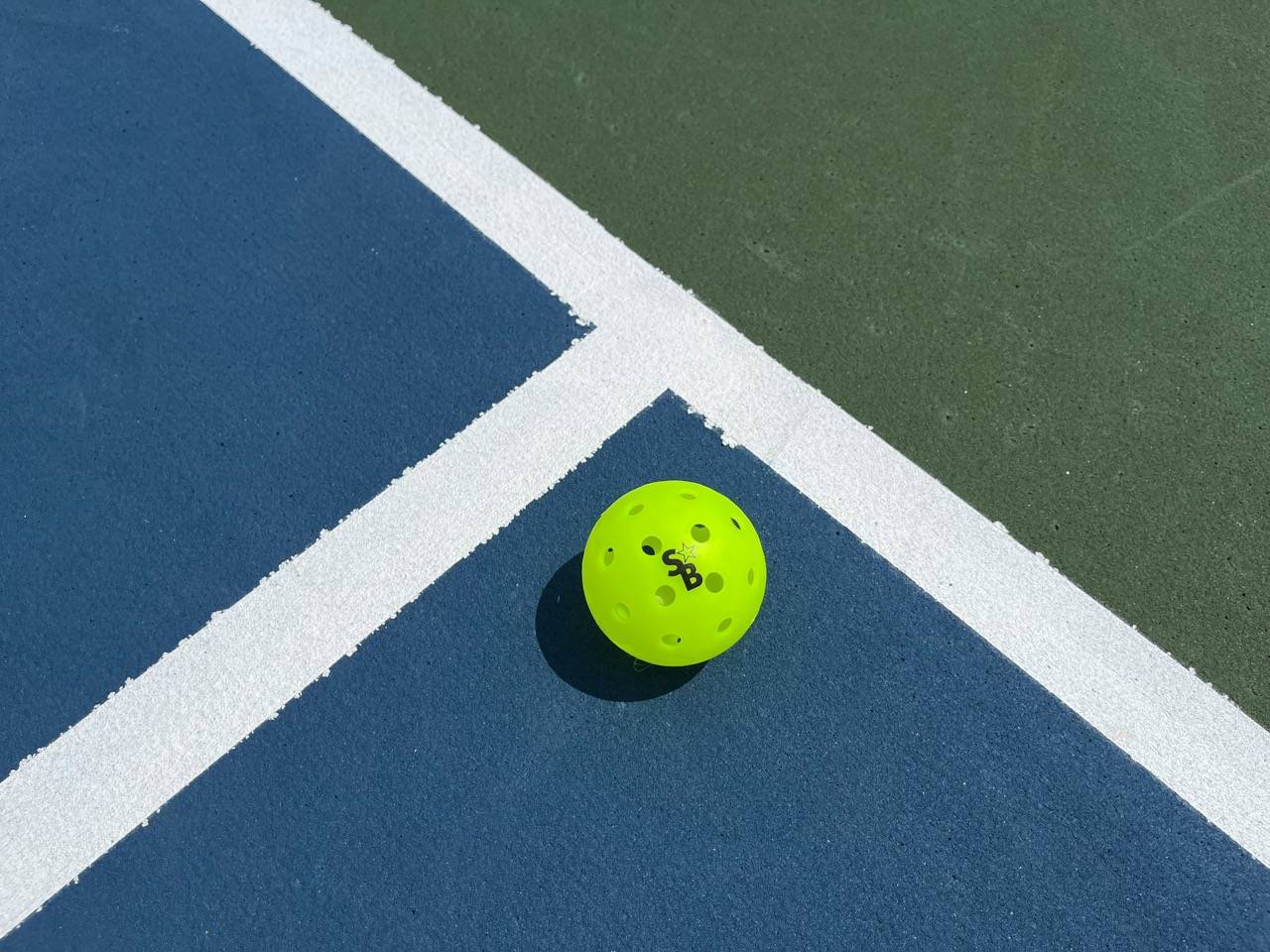A pickleball on the pickleball court. 