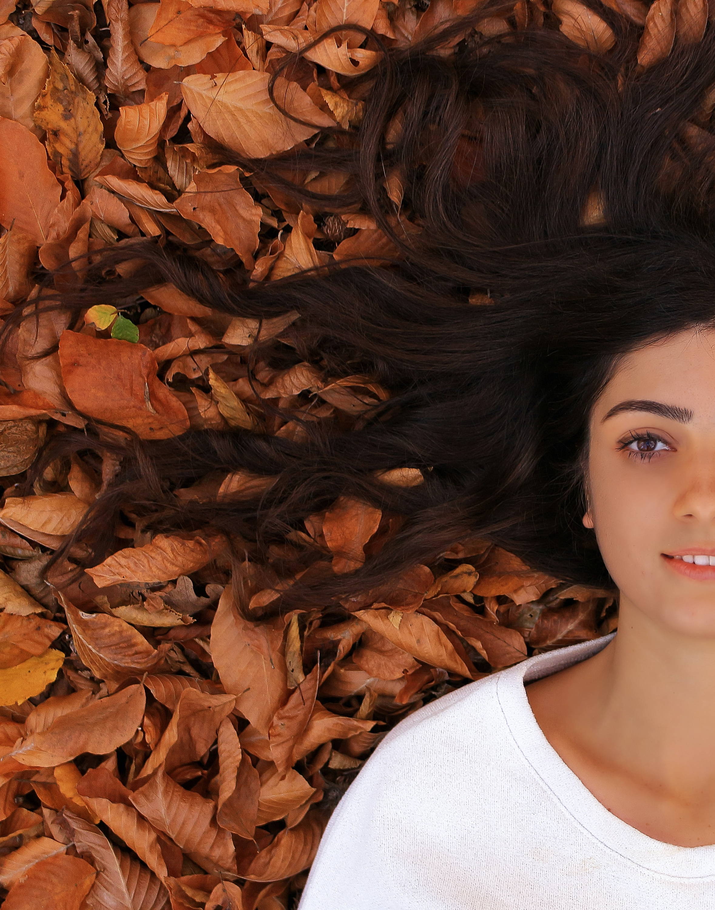 image of wavy hair women on autumn leaves