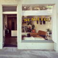 Sealevel Studio window with blinds up, door is open welcoming you in