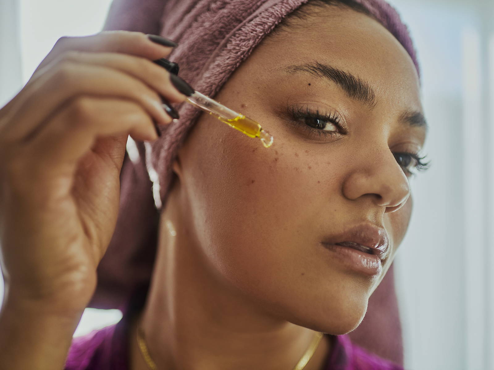 woman applying serum on her face